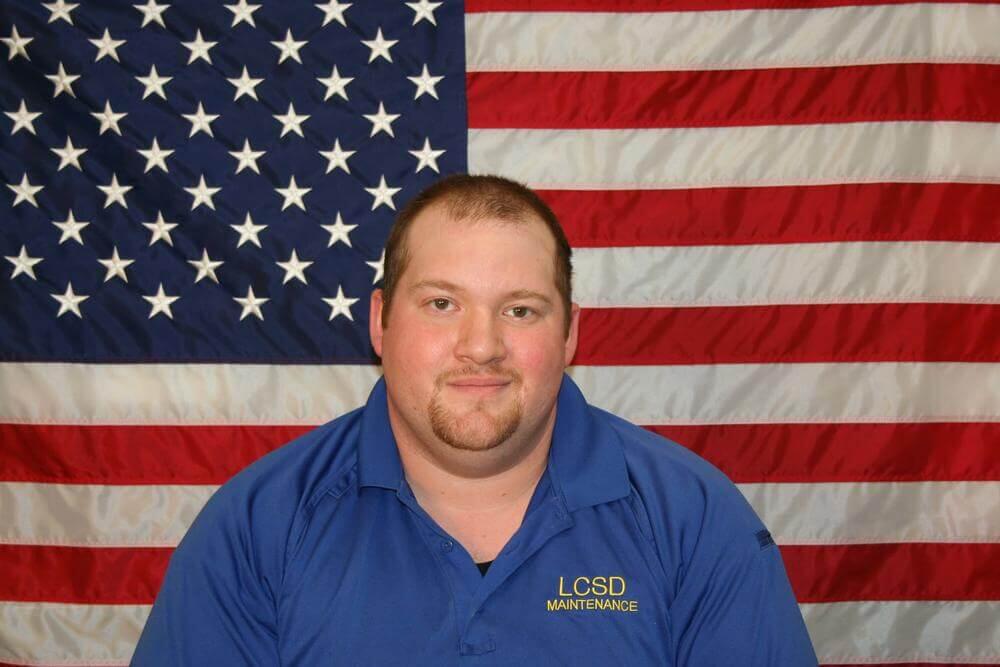 Facilities Supervisor Jeffrey Foreman in front of American Flag