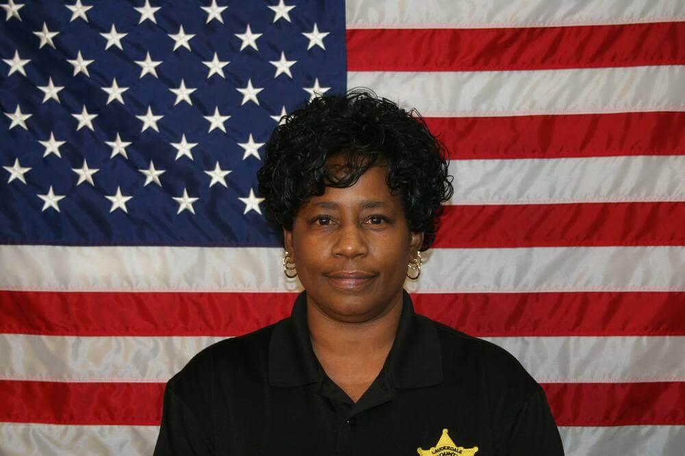 Sgt. Ruth Parker standing in front of the flag of the United States of America.