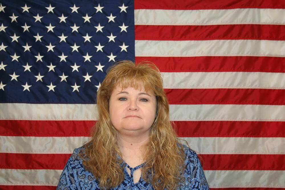 Edna Barfield standing in front of the American Flag