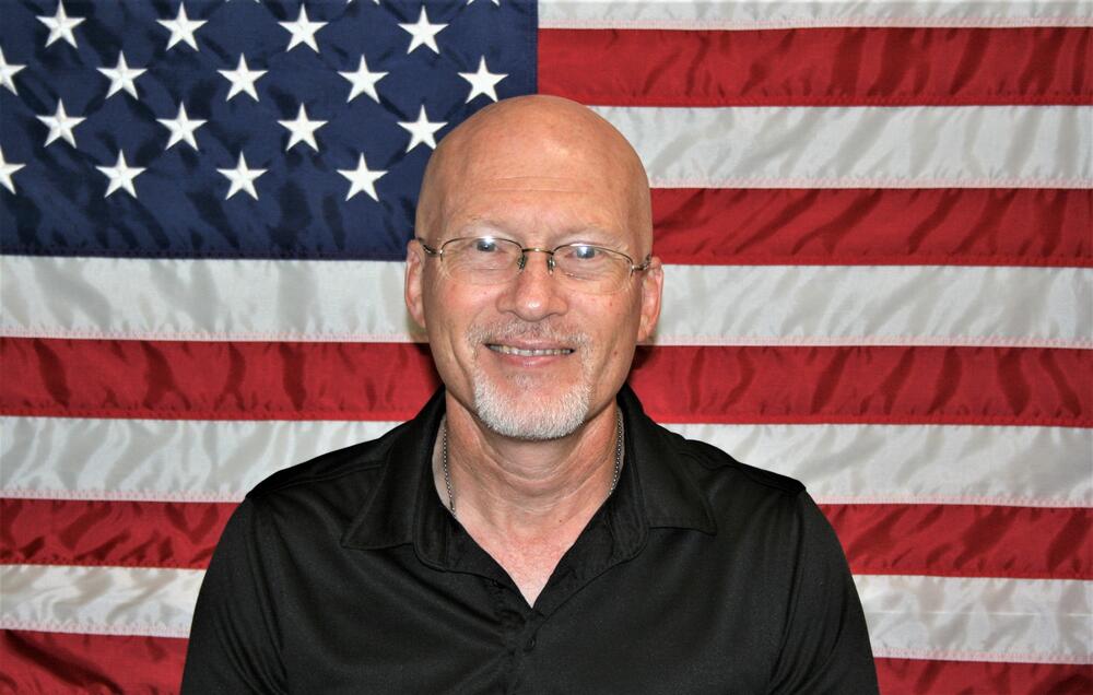 Chaplain Roy McNeill with American Flag Backdrop