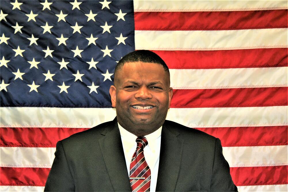 Investigator Chris McFarland with American Flag backdrop