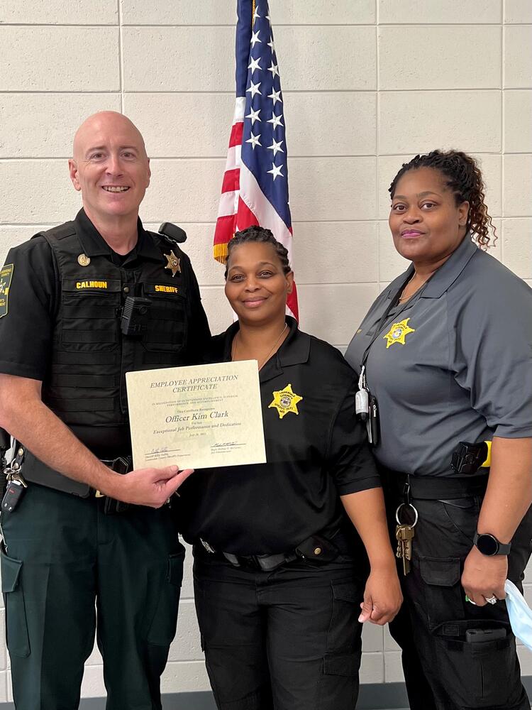 Lauderdale County Sheriff's Chief Deputy/Detention Officer Kim Clark/Detention Lt. Miria Rainey acknowledge officer of the month Clark holding honor certificate