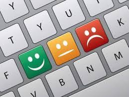 Computer keyboard with green smiley face, yellow resting face and red frowning face. 