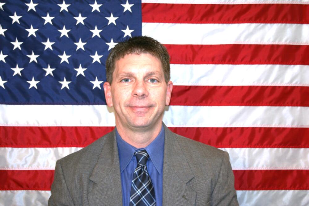 White male with a light suit on.
